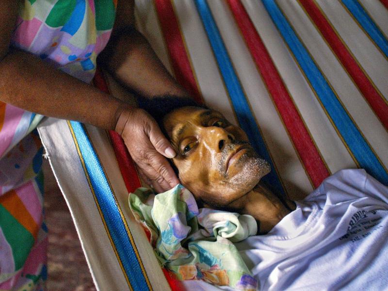 Luz Maria Marin holds the head of her husband Angel Toala the day before he died of stomach cancer in his home in Shushufindi. Photo Credit: Lou Dematteis, from Crude Reflections