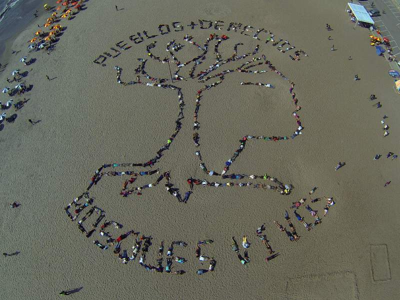 Hundreds of indigenous peoples and their allies used their bodies to create a human banner on Agua Dulce beach in Lima, Peru parallel to the UN COP20 climate summit to demonstrate the importance of guaranteeing territorial rights in addressing climate change. Photo Credit: Amazon Watch / Spectral Q