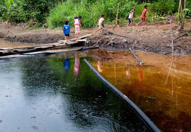 Kichwa children cross an oil-contaminated pond in Rumipamba. Photo credit: Mitch Anderson