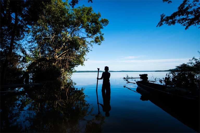 A member of the Munduruku indigenous group stands beside the Tapajós River, Pará state, Brazil. The Munduruku's Sawré Muybu territory on the Tapajós is threatened by a proposed dam complex including the São Luiz do Tapajós dam. Those territorial claims were recently recognised by the Brazilian government, putting the licensing of the dam in doubt. Photo credit: Valdemir Cunha / Greenpeace