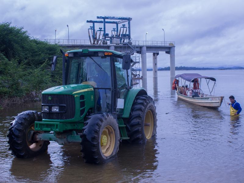 Altamira, Brazil. The transportation “system of the future” consists of a tractor that drags a boat out of water with the help of a worker that needs to get in the water for it to work. The boat’s passengers are then taken by van to the other side of the river where their boat is lowered into the water and allowed to continue on its way. Photo credit: Maira Irigaray / Amazon Watch
