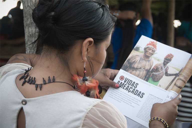 A Munduruku woman reads an article about dam-related conflicts during the meeting. Photo credit: Anderson Barbosa of the Anderson Barbosa / Fractures Collective.