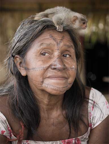 A Munduruku woman with a baby monkey attending a November 2013 assembly in Restinga village in the Munduruku Indigenous Territory. Photo credit: Anderson Barbosa of the Anderson Barbosa / Fractures Collective.